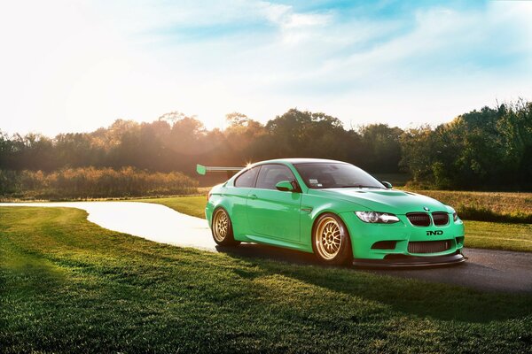 Green BMW on a sunny road