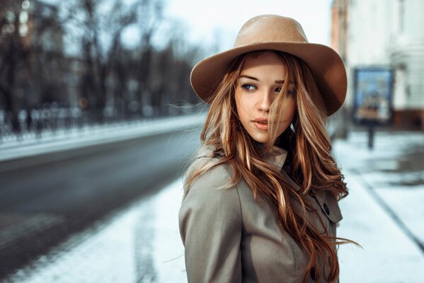 Chica con sombrero en el fondo de la carretera