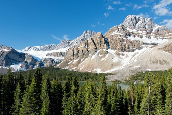 A PARK WITH A LAKE AT THE FOOT OF THE CANADIAN MOUNTAINS