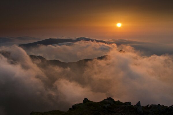 Sole al tramonto sulle montagne e nebbia