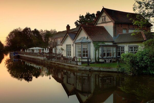 Reflexion des Sonnenuntergangs am Fluss, in der Nähe des Hauses