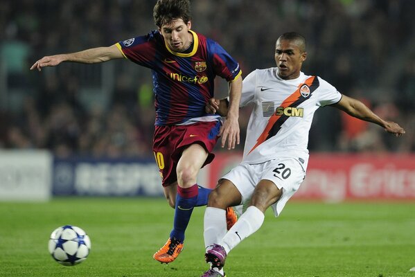 Two football players on the field are fighting for the ball