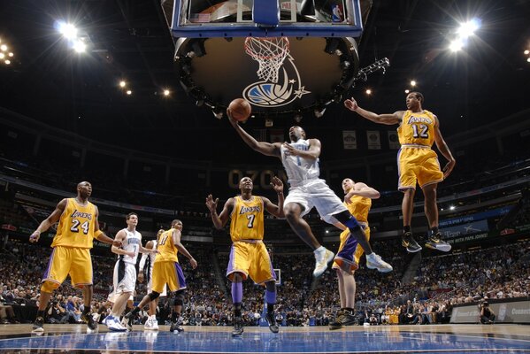 A basketball player with a ball in a jump to the ring