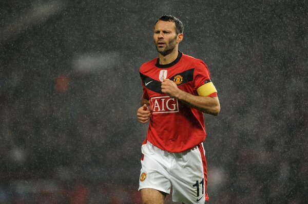 Footballeur en t-shirt rouge et short blanc