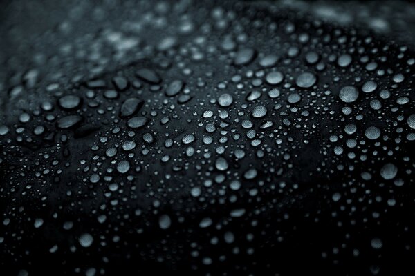 Pequeñas gotas de lluvia sobre un fondo negro, para un estado de ánimo triste