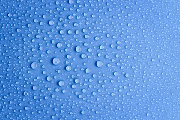 Gotas de agua sobre fondo azul bajo macro