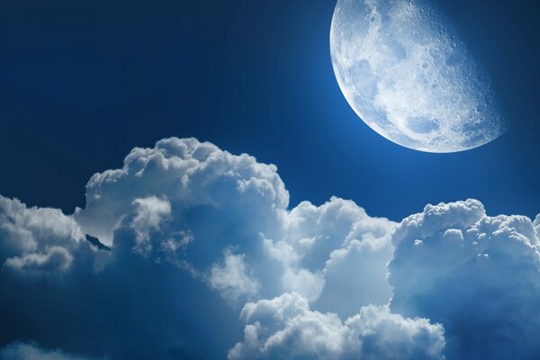 Leuchtender Mond am Nachthimmel in flauschigen Wolken
