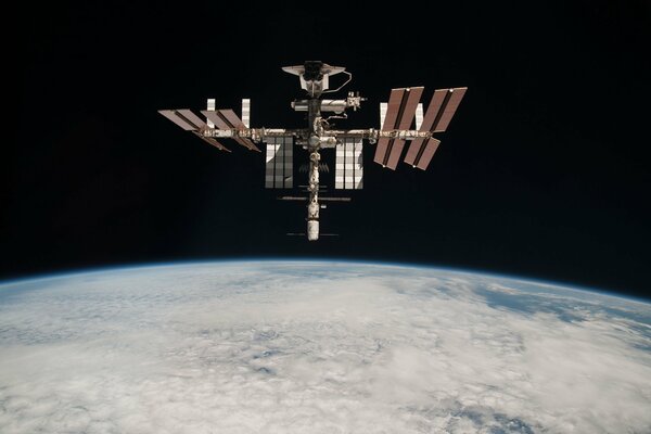 Amarrage de la navette et de l ISS sur fond de nuages de l atmosphère terrestre et de l espace noir