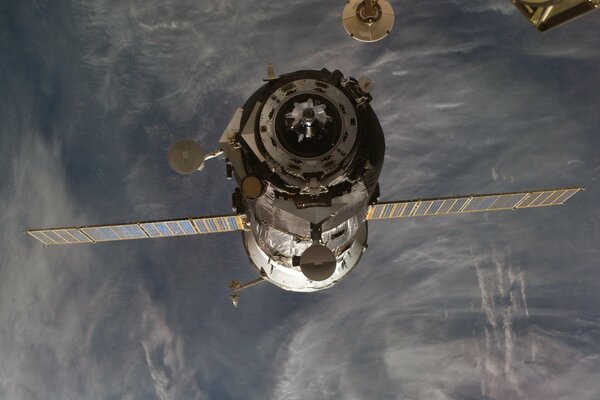 Un satélite en el espacio en órbita contra el fondo de la tierra