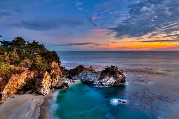 Coucher de soleil éclatant sur la côte rocheuse près de l océan