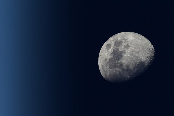 A crescent moon in a starless night sky