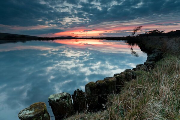 Reflejo de la puesta de sol y el cielo en el lago