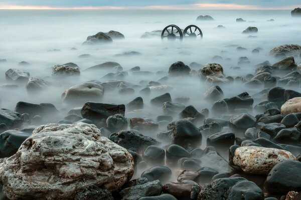 Costa del mar con piedras en la niebla