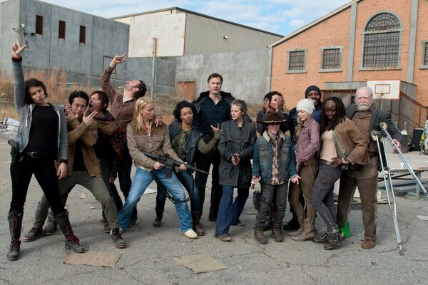 People pose against the background of nondescript buildings