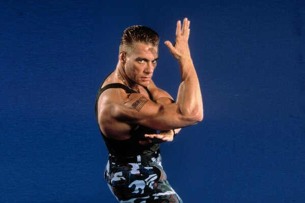 Jean-Claude van Damme poses on a blue background