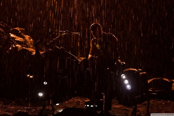 Silhouette d un homme debout sous la pluie à côté des projecteurs