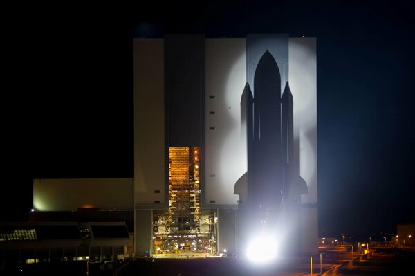 Silueta del transbordador espacial con el fondo de la ciudad nocturna