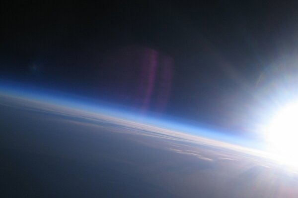 The Earth is in the atmosphere. The sun setting behind the planet