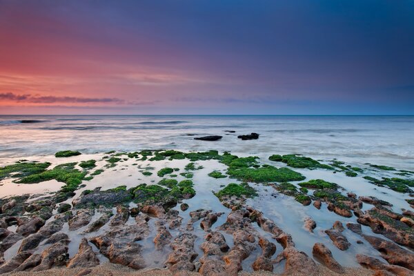 Ciel peint dans différentes couleurs et les récifs dans la mer