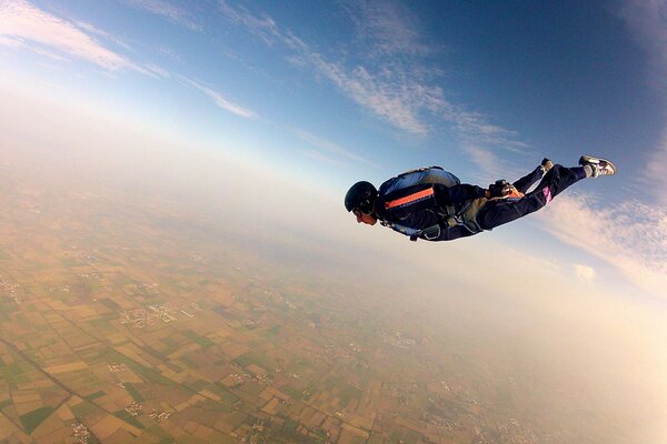 A parachutist with an unopened parachute in the open sky