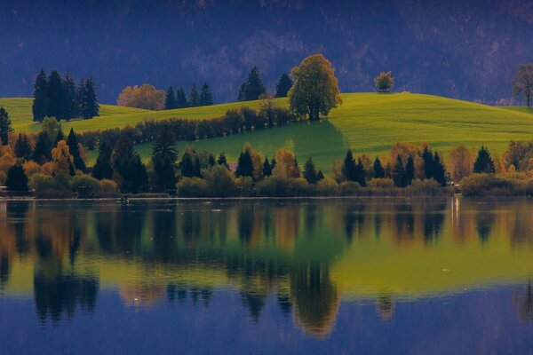 The hill is reflected in the river surface