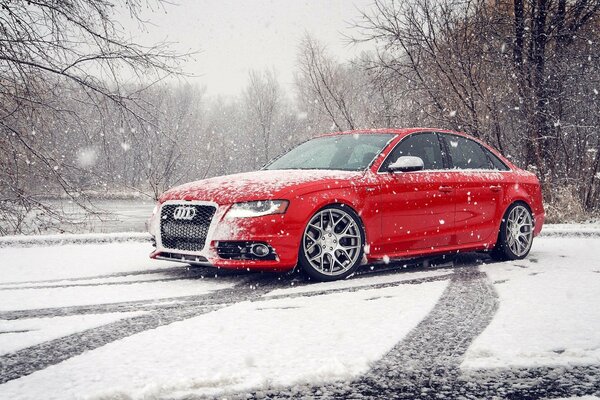 Audi rojo en la naturaleza en invierno, en la nieve