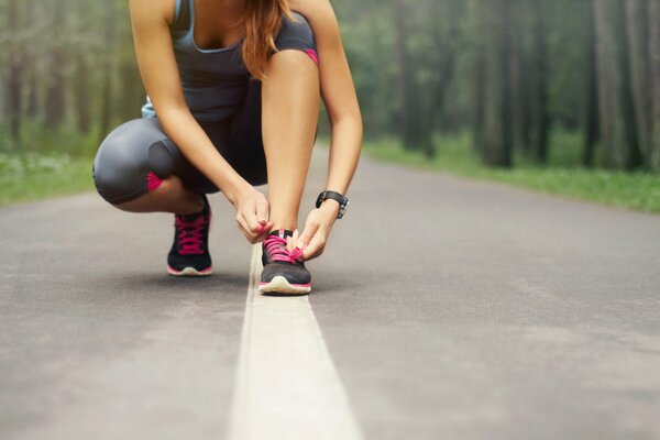 A girl on the road ties her shoelaces