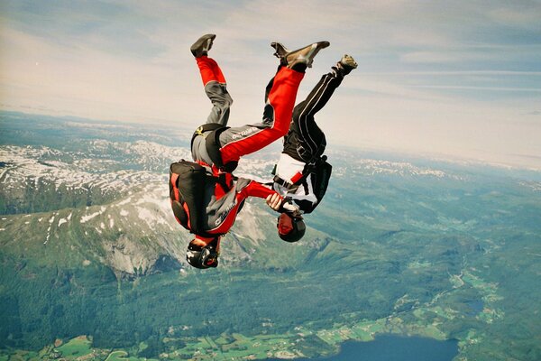 Parachutists on the background of mountains. Jump upside down