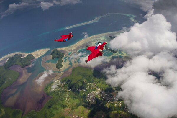 Fallschirmspringer fliegen über Meer und Wolken