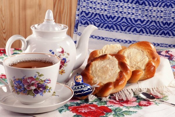 Foto di tè in una teiera e una tazza, così come cheesecake con ricotta