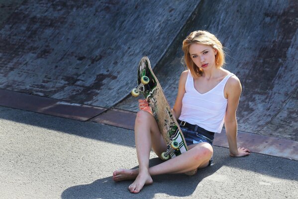 A girl is sitting on a skateboard