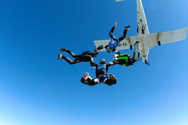 Parachutists soaring in the sky holding hands