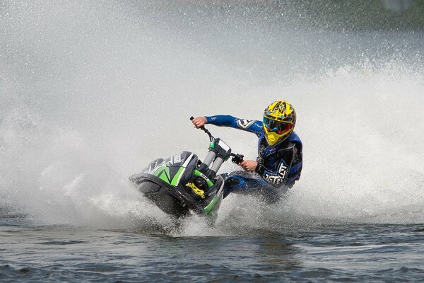 An athlete in a yellow helmet rushes on a jet ski