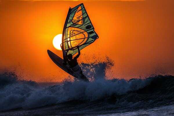 Surfea las olas al atardecer en el océano