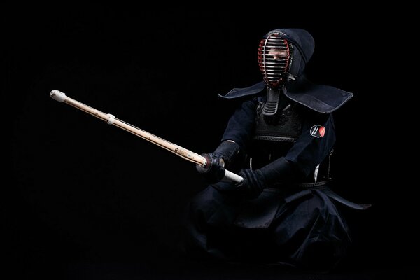 Luchador de kendo con uniforme negro listo para enfrentar a su oponente