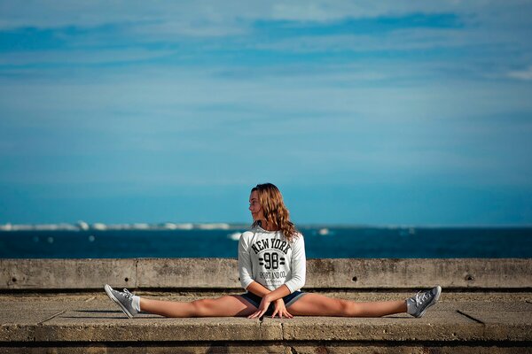 A girl on a twine on the background of the sea