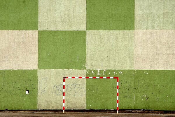 Football goal on the background of a green wall. Tricolor background green