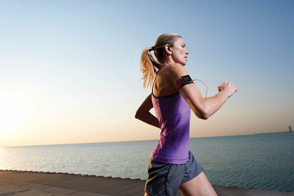 Running girl on the edge of the ocean