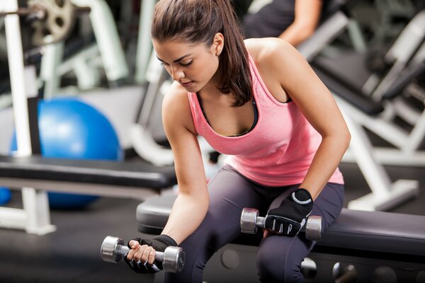 Mujer en el gimnasio con mancuernas