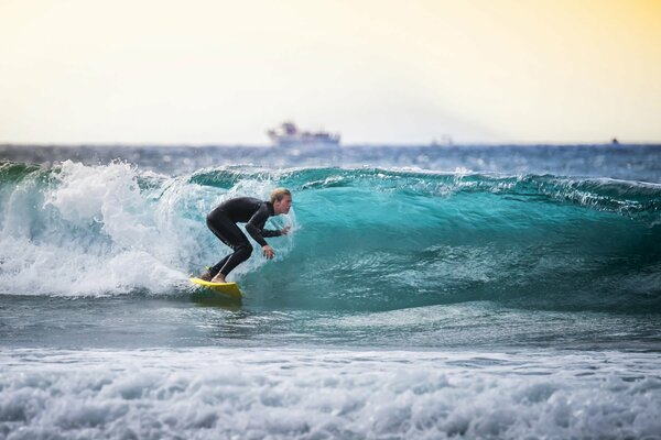 Surfista y barco en el horizonte