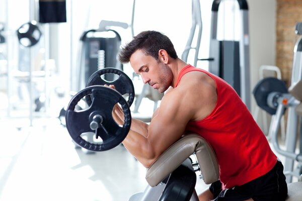 Hombre ejercita bíceps en el gimnasio