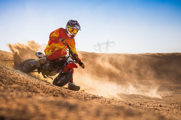 Motocross in the sands of the enduro desert and a bright outfit