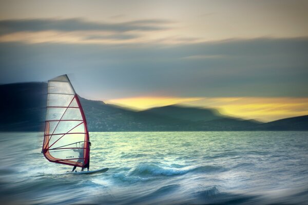 Homme sur la voile dans la mer. La voile