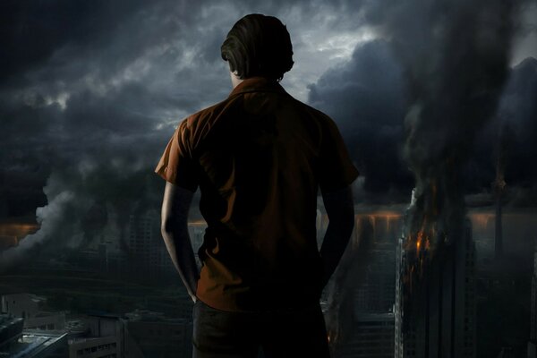 A man looking at a burning city