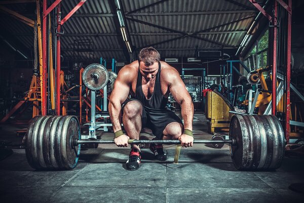 Muskularny sportowiec podnosi ciężki ciężar