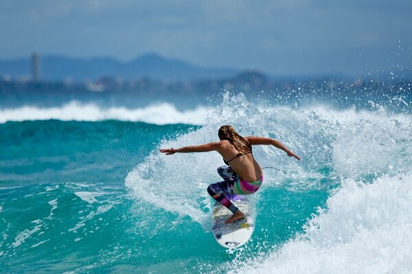 A girl on a surfboard is floating on a wave