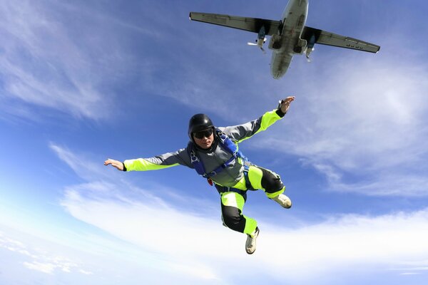 Foto von einem Fallschirmspringer am Himmel, der aus einem Flugzeug springt