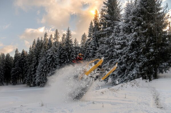 Moto de nieve en un salto en el fondo del bosque de invierno