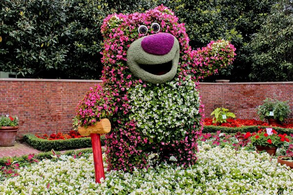 Escultura de oso de flores con martillo