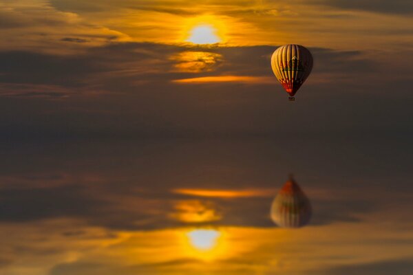 Reflet dans l eau d un ballon volant au coucher du soleil